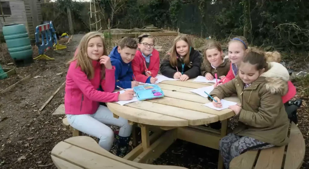 Children from Llanciach Fach Primary School writing and learning outdoors at Tony O'Neill's allotment, Nelson, Caerphilly, South Wales