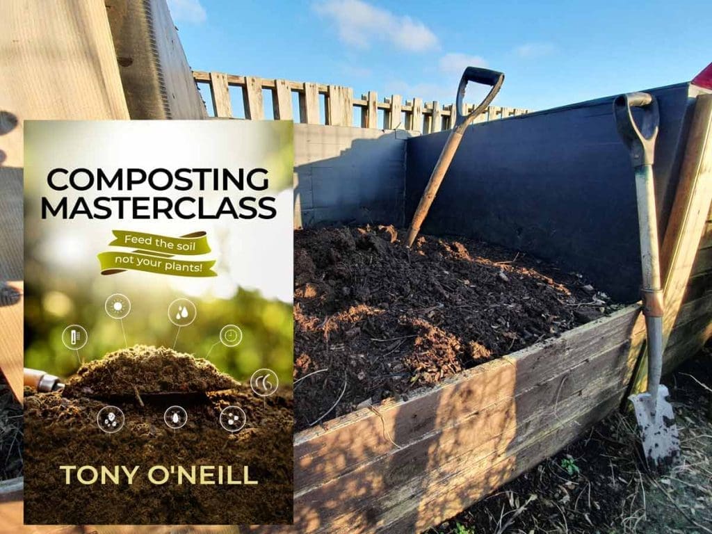 Tony O'Neill turning an active compost bay at his South Wales allotment, with three buckets of fresh green and brown compost material in the foreground and steam rising from the hot compost pile, allotment plots visible in the background
